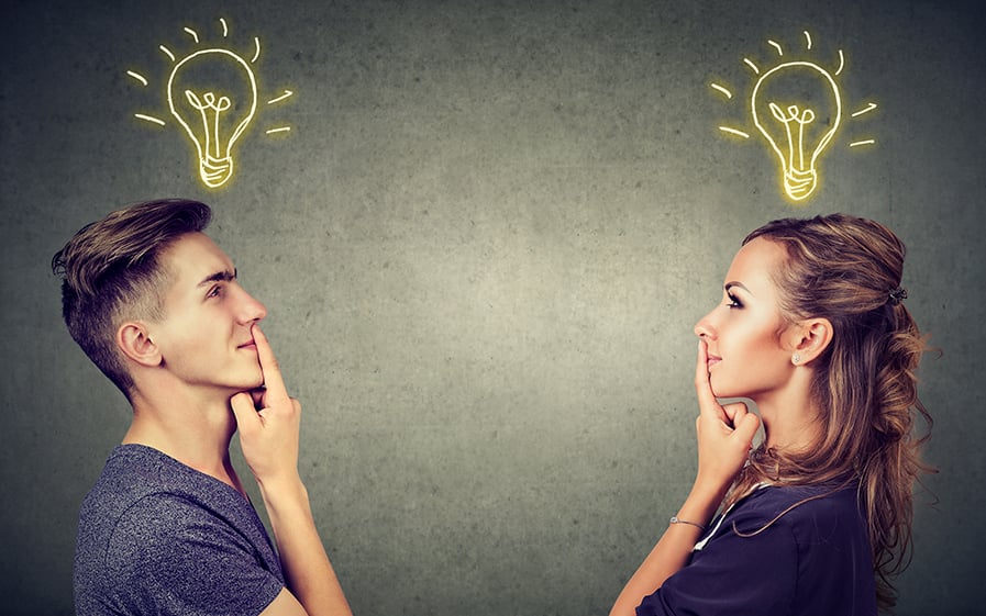 two people looking at each other with a light bulb above their heads